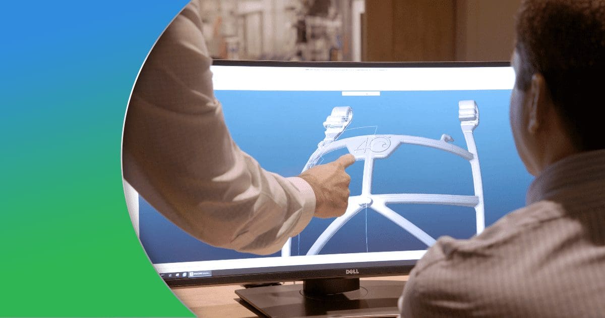 Workers looking at rendered design on computer monitor